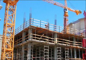 Crane and building construction site against blue sky