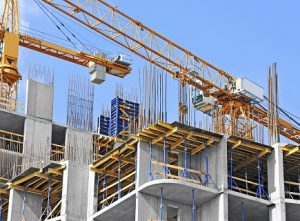 Crane and building construction site against blue sky