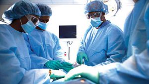 Medical Doctors operating a patient. Credit: The Guardian website